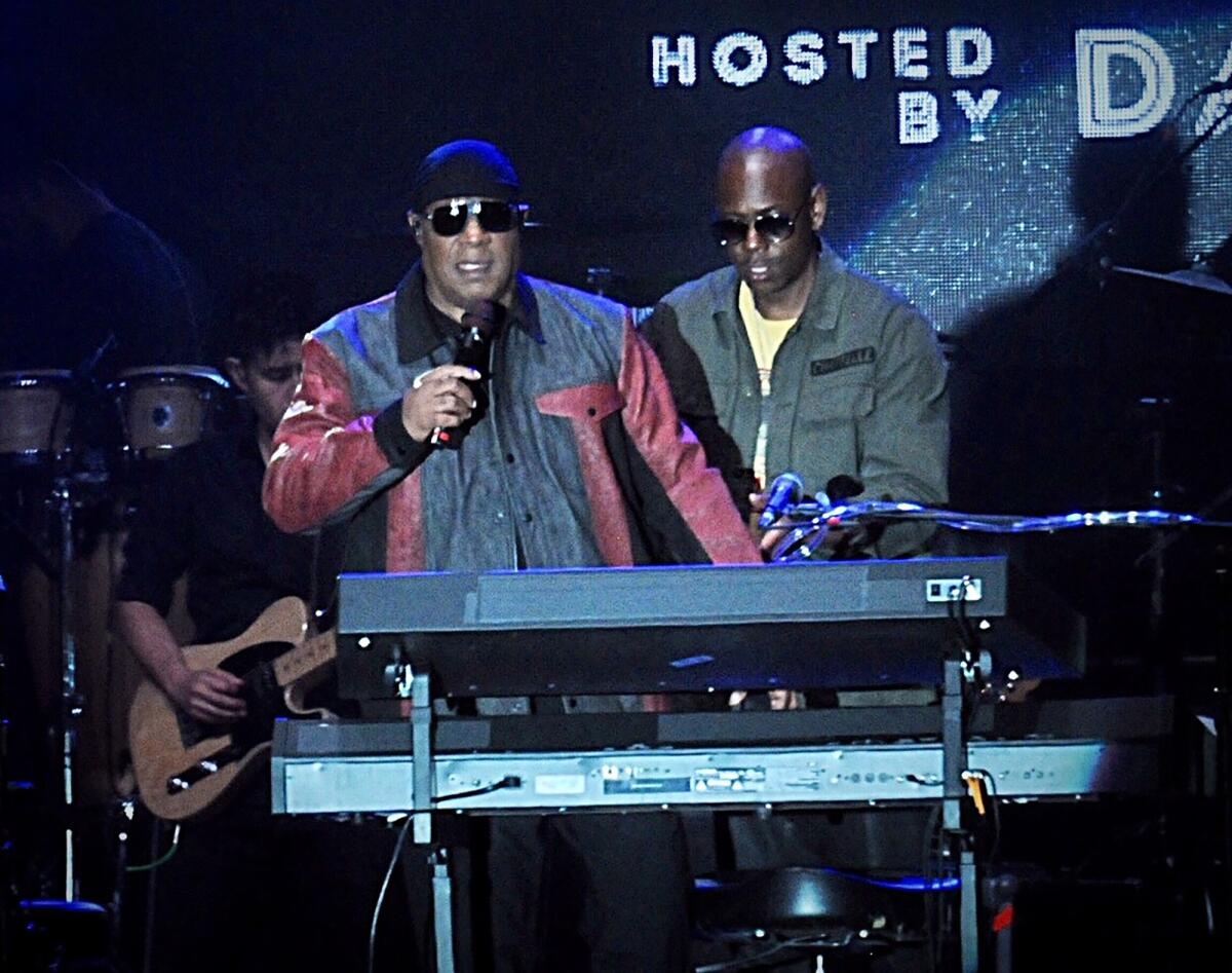 Musician Stevie Wonder, front left, and comedian Dave Chappelle appear on stage during the Gem City Shine event