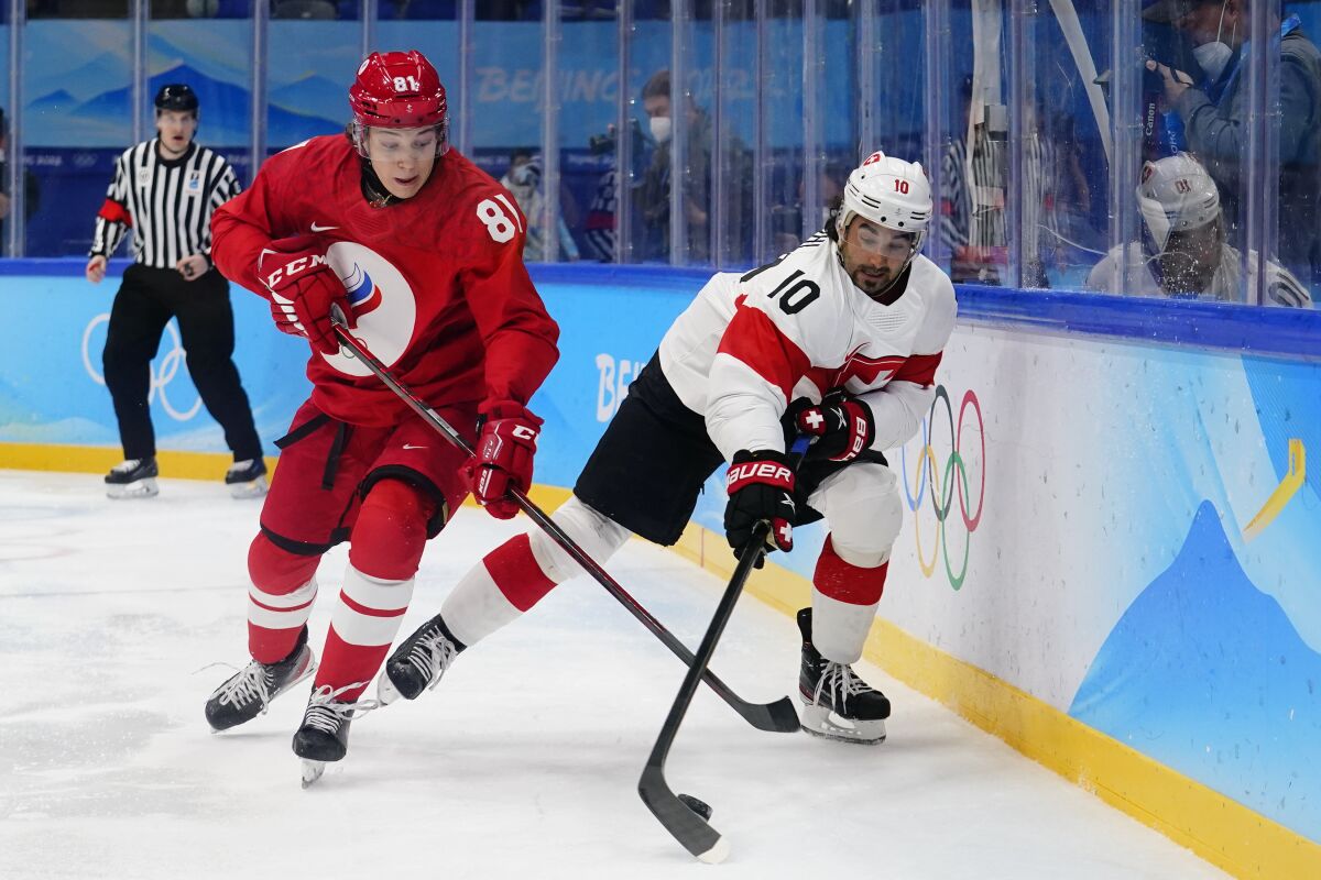 Russian Olympic Committee's Arseni Gritsyuk (81) and Switzerland's Andres Ambuhl (10) chase down the puck during a preliminary round men's hockey game at the 2022 Winter Olympics, Wednesday, Feb. 9, 2022, in Beijing. (AP Photo/Matt Slocum)