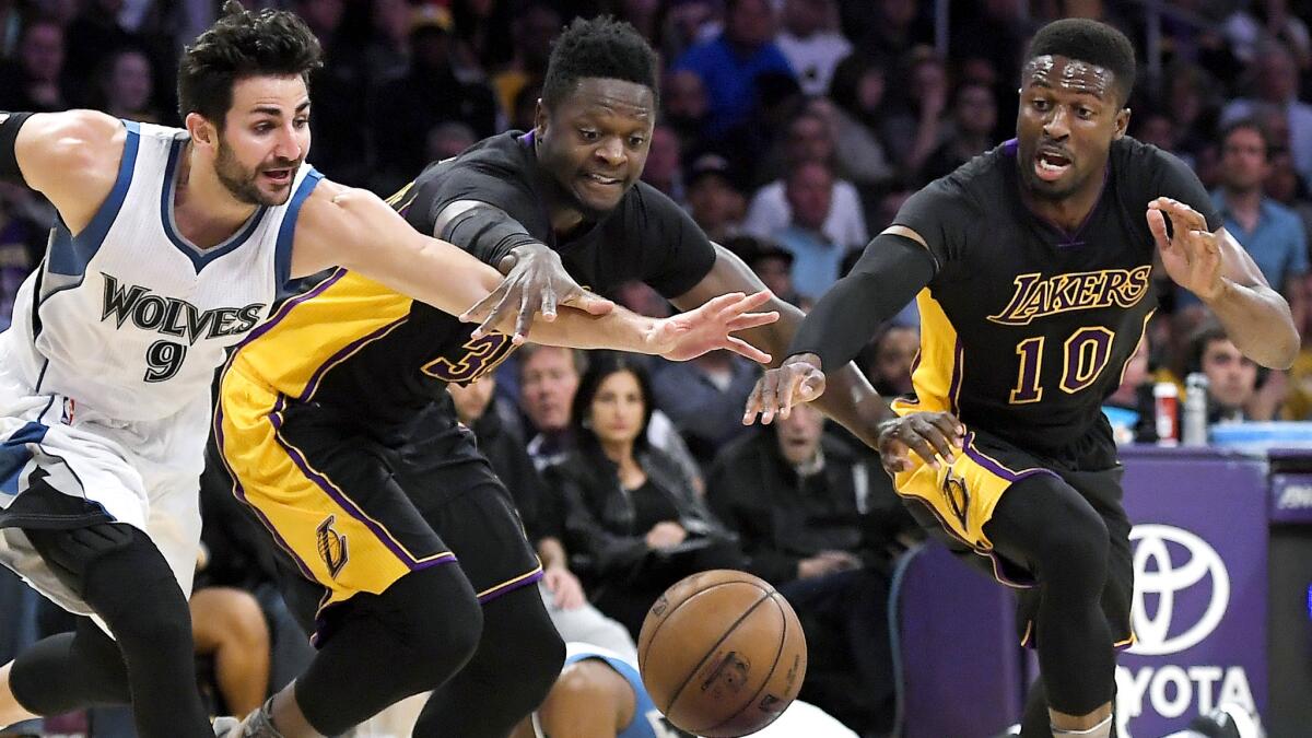 Lakers forward Julius Randle, center, and guard David Nwaba, right, chase after a loose alongside Timberwolves guard Ricky Rubio during the first half Friday. (Mark J. Terrill / Associated Press)