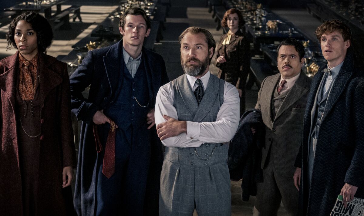 A group of people in old-fashioned clothing looking upward in a scene from “Fantastic Beasts: The Secrets of Dumbledore."