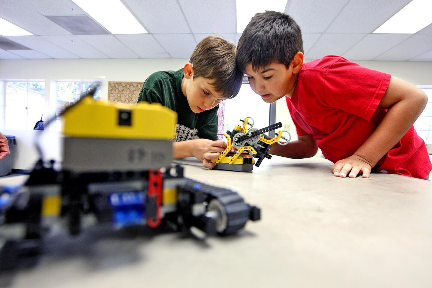 Spencer Solberg, 9, and Julian Grigorian, 9, take a closer look a Lego robot during a robotics class at Verdugo Park on Thursday, March 27, 2014.