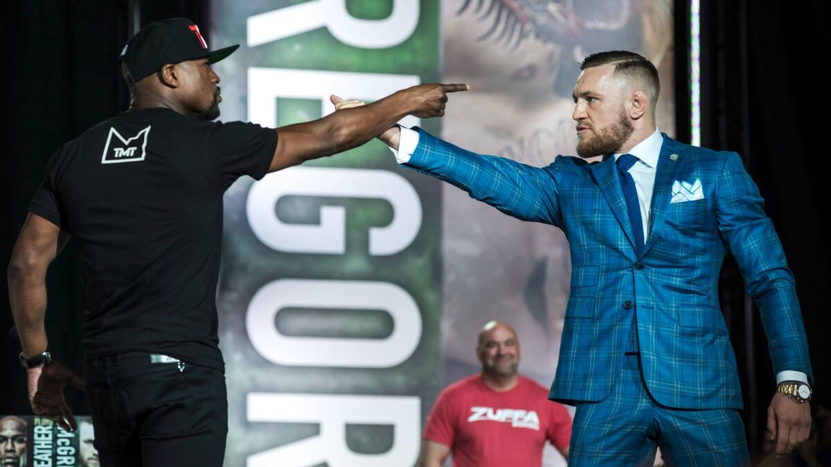 Floyd Mayweather, left, and Conor McGregor exchange harsh words during a promotional stop in Toronto on July 12.