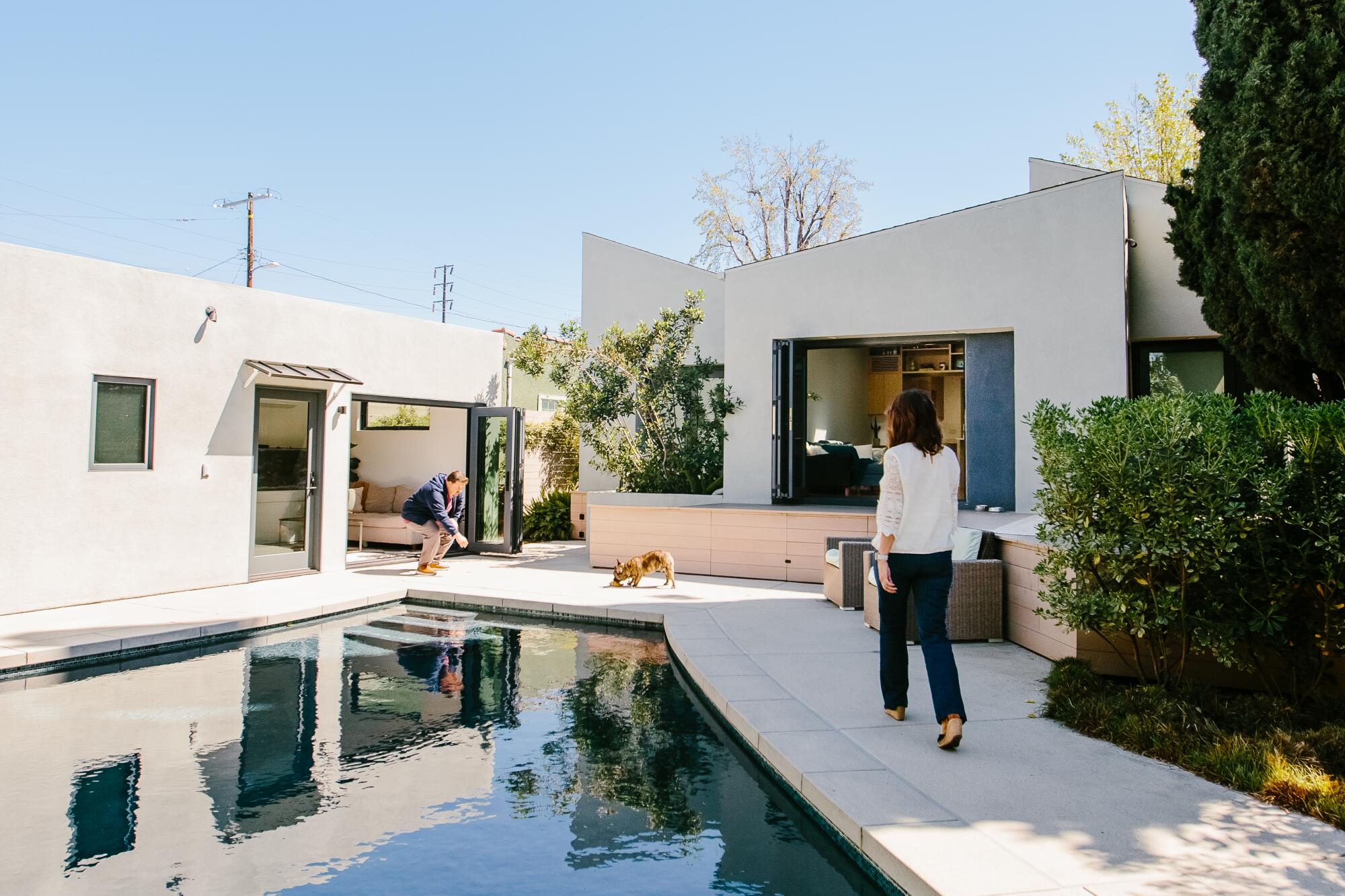 A couple outside their home, ADU and swimming pool 