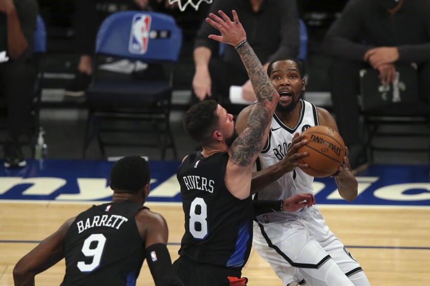Brooklyn Nets forward Kevin Durant (7) drives to the basket against New York Knicks guards Austin Rivers (8) and RJ Barrett (9) during the first quarter of an NBA basketball game Wednesday, Jan. 13, 2021, in New York. (Brad Penner/Pool Photo via AP)