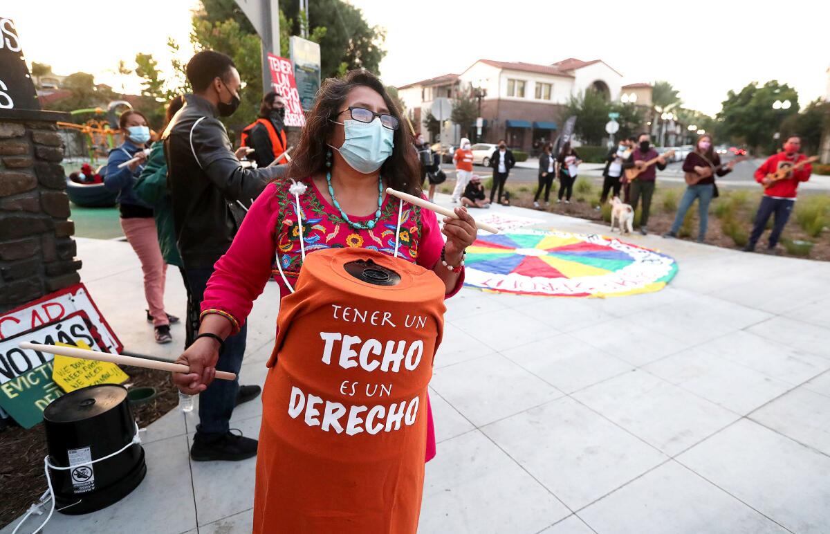 A rent control supporter bangs on a drum during a demonstration in Santa Ana.