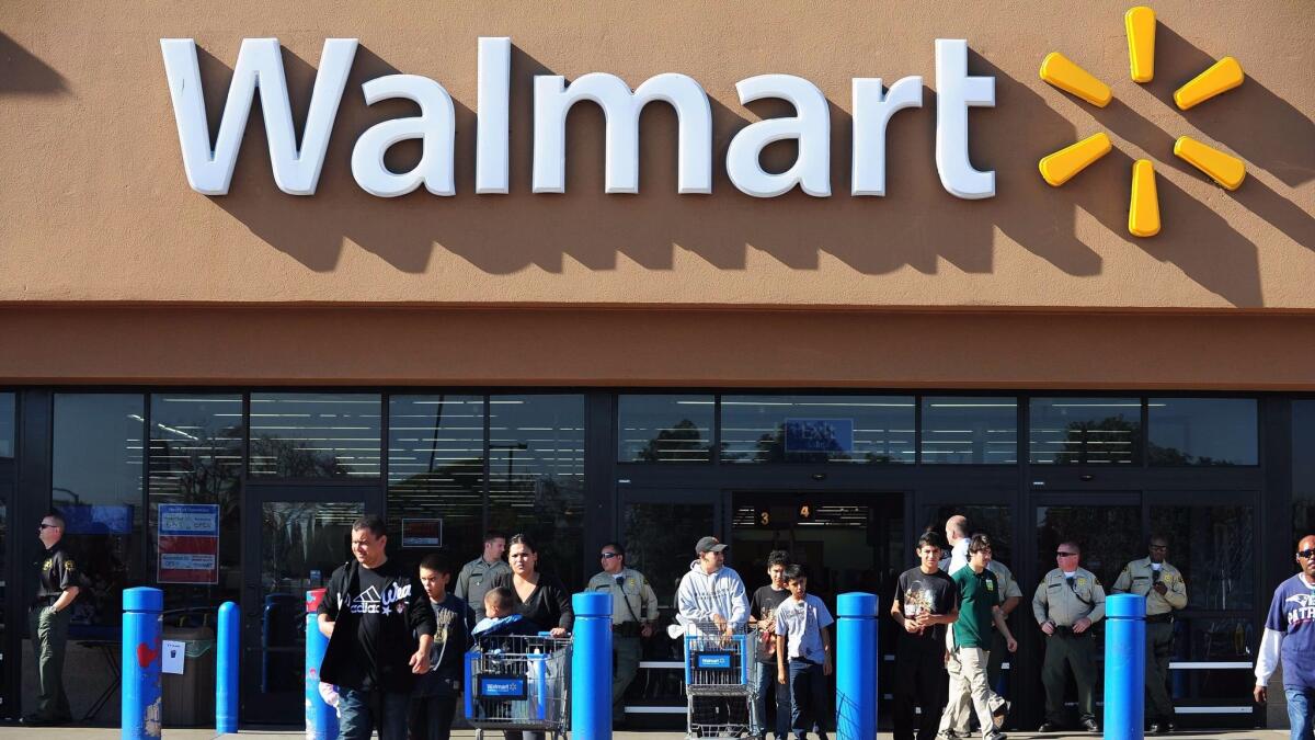 Shoppers are seen in front of a Wal-Mart store.