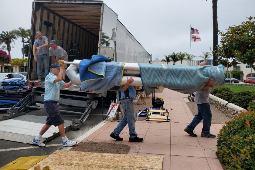 Volunteers help unload the pipes from a truck to the hall of St. James by-the-Sea Episcopal Church.