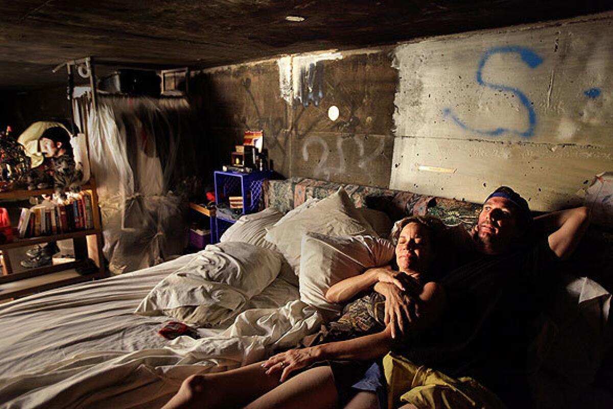 Steve, right, and his girlfriend Kathryn (they asked that their last names and ages not be used) lie in their large bed in a storm drainage tunnel under the city of Las Vegas. The pair, who have one of the more elaborate encampments among the tunnel-dwellers, have many of the comforts of a real home, but lack electricity and running water.