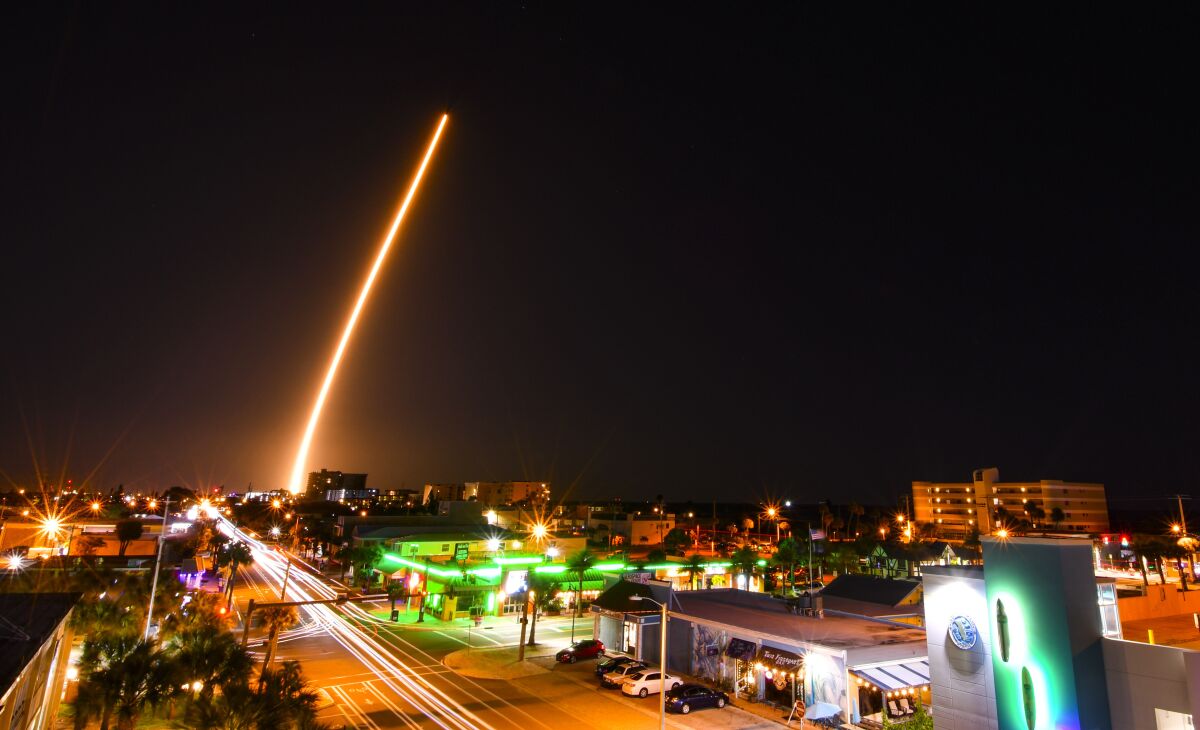 In a time exposure, a SpaceX Falcon is launched from Cape Canaveral, Fla., Friday night, March 6, 2020, with a load of supplies for the International Space Station. Cocoa Beach, Fla., is in the foreground. (Malcolm Denemark/Florida Today via AP)