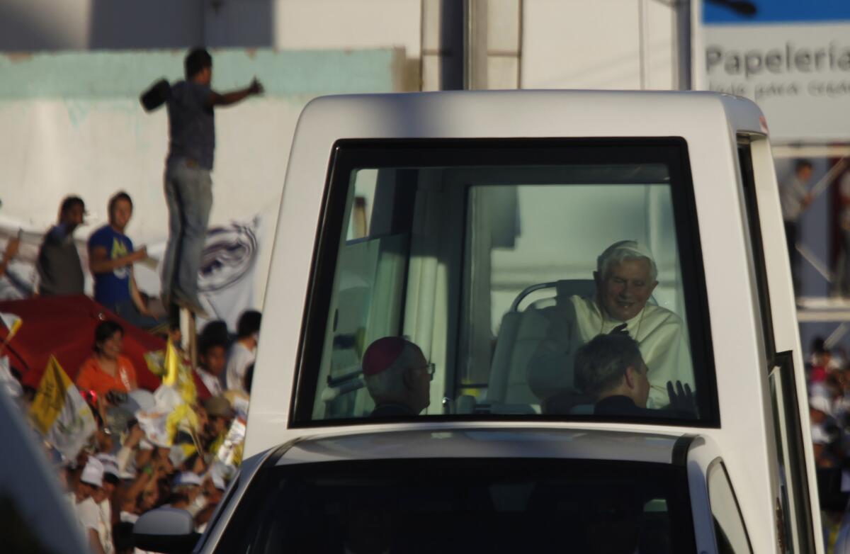 Pope Benedict XVI waves to well wishers from the Popemobile in Leon, Mexico, on March 23, 2012.