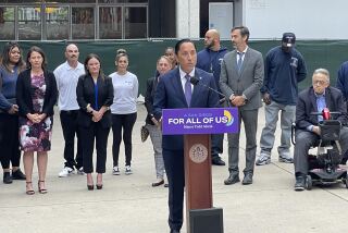 San Diego Mayor Todd Gloria stands at a podium to announce increased services for homeless people. 