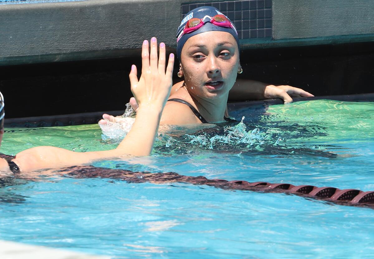Corona del Mar's Nikki Lahey high-fives an opponent after the girls' 200 yard freestyle relay on Saturday.
