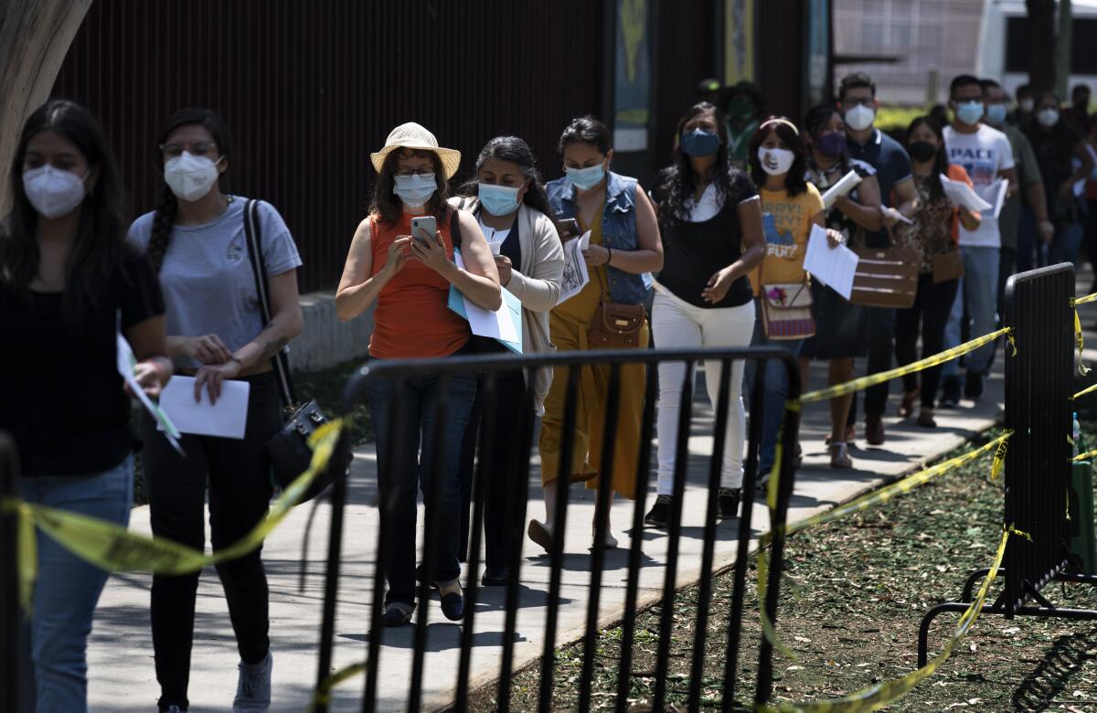 Educadoras hacen fila para que les pongan la vacuna de CanSino contra el COVID-19 