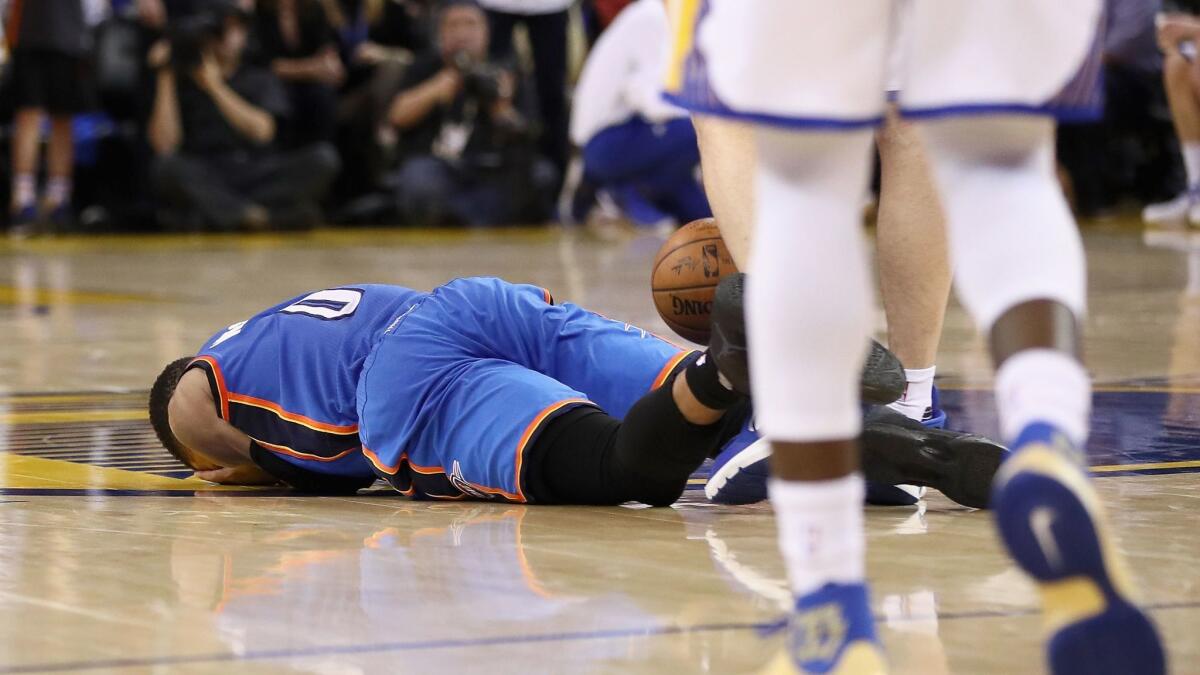 Oklahoma City's Russell Westbrook lies on the court after being fouled by Golden State's Zaza Pachulia on Jan. 18.