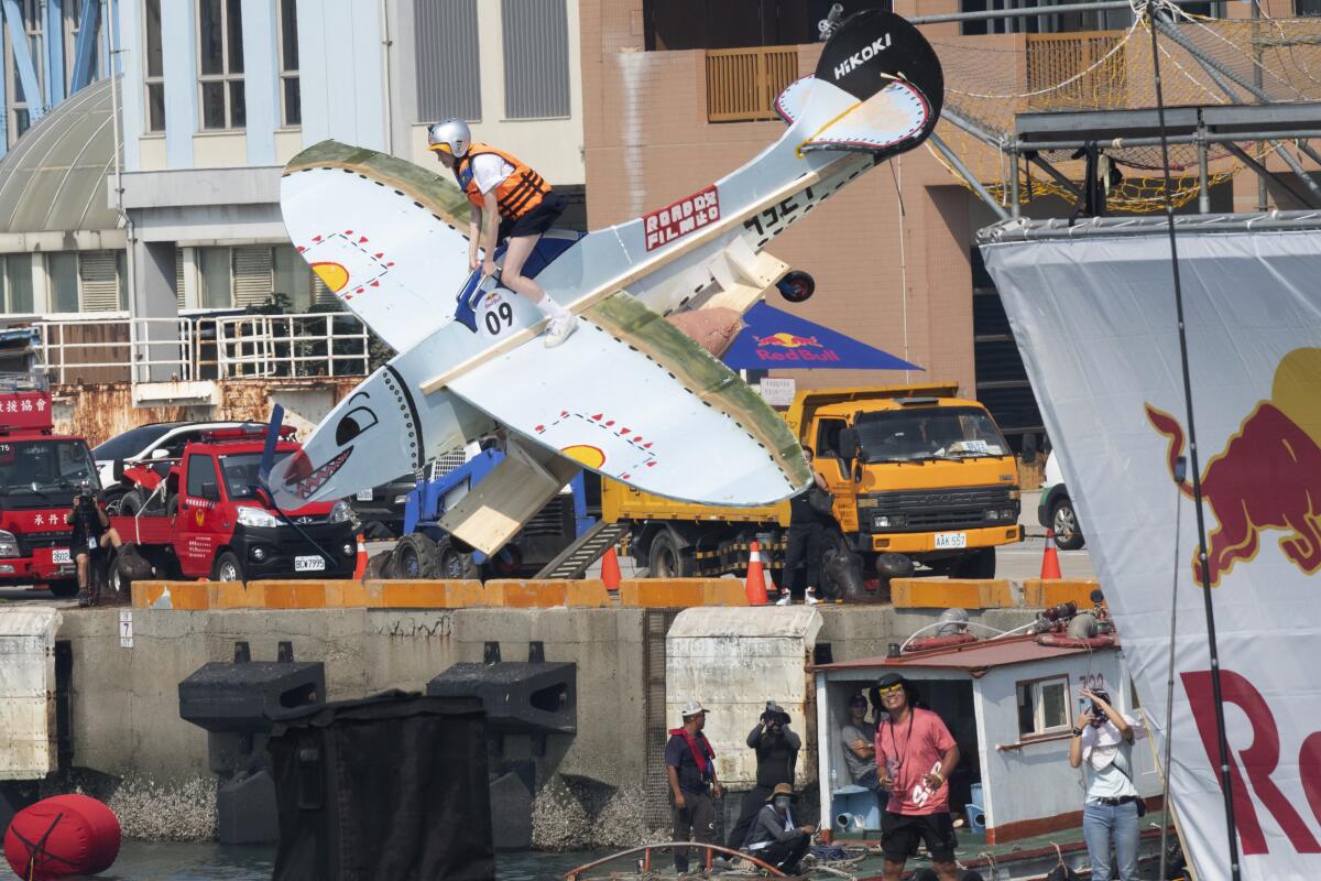 Un participante salta al agua desde una plataforma con una máquina voladora de fabricación casera en el puerto de Taichung, Taiwán, el domingo 18 de septiembre de 2022. (Foto AP/Szuying Lin)