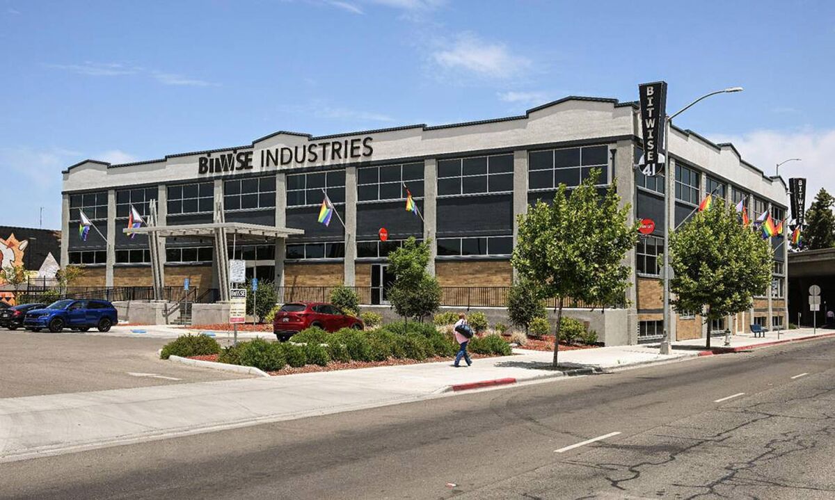 An three-quater exterior frame of a two-story building with "Bitwise Industries" sign near the roof, above main the door.