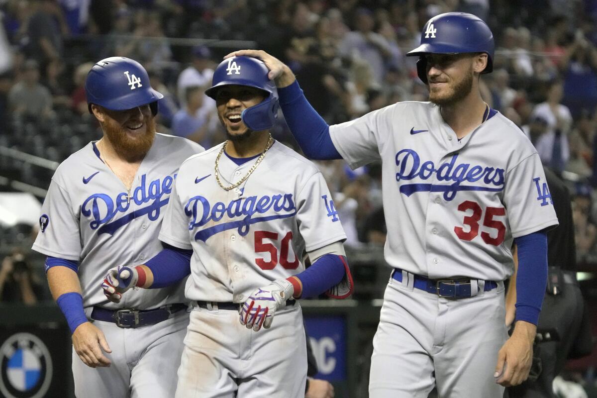 The Dodgers' Mookie Betts celebrates with Justin Turner and Cody Bellinger after hitting a three-run home run.