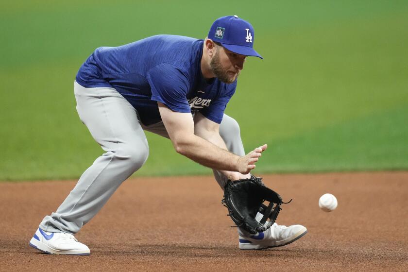 Los Angeles Dodgers third baseman Max Muncy fields a ground ball during a baseball workout.