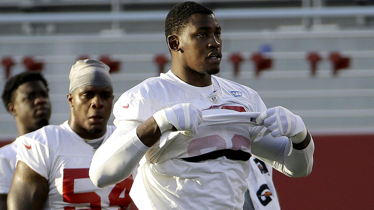 San Francisco 49ers linebacker Aldon Smith lifts his jersey during the team's NFL football training camp in Santa Clara, Calif., on Saturday.