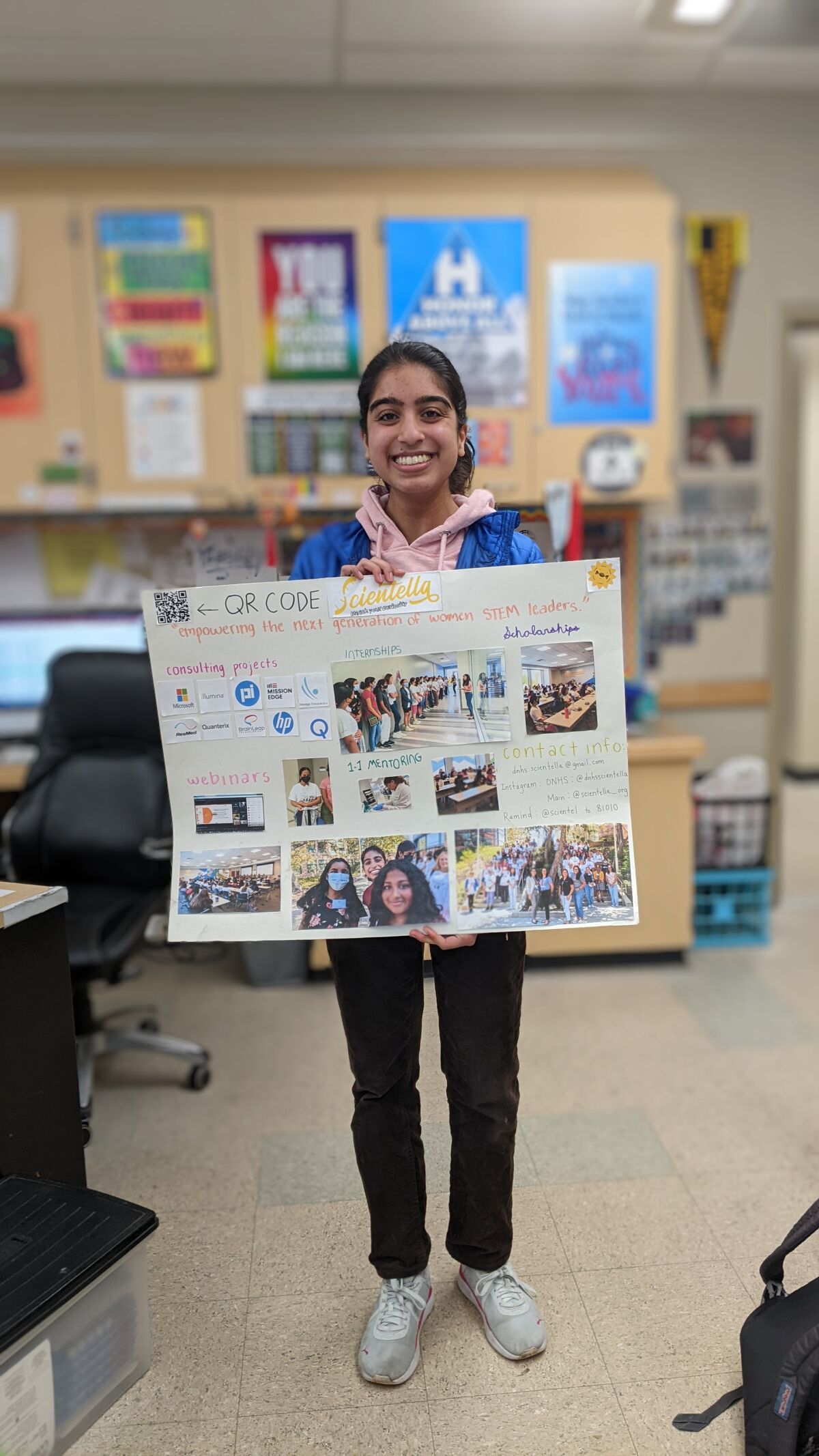 Zinia Khattar holding a collage showcasing work by Scientella members.