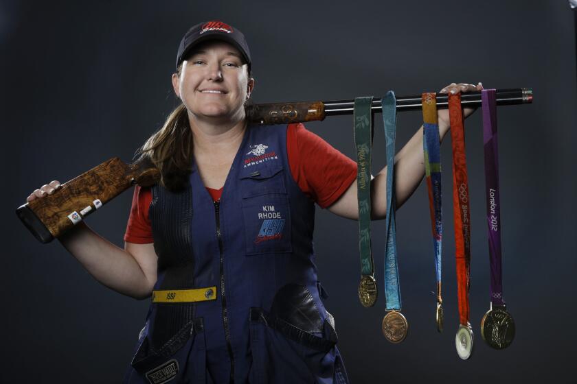 FILE - In this March 8, 2016, file photo, double trap and skeet shooter Kim Rhode poses for photos with her Olympic medals at the 2016 Team USA media summit in Beverly Hills, Calif. Misfortune stacked up like spent shotgun shells in the four years since Kim Rhode won her third Olympic gold medal. (AP Photo/Jae C. Hong, File)