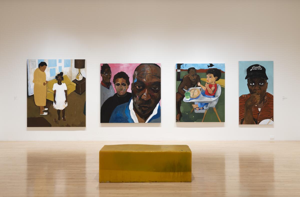 A view of a gallery shows a bright yellow bench before a row of four paintings that feature Henry Taylor and his family.
