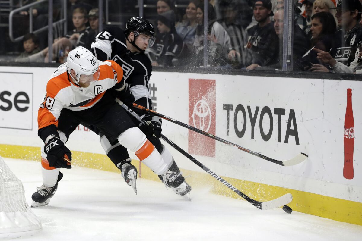 Flyers center Claude Giroux and Kings defenseman Ben Hutton battle along the boards behind the net during the first period of a game Dec. 31 at Staples Center.