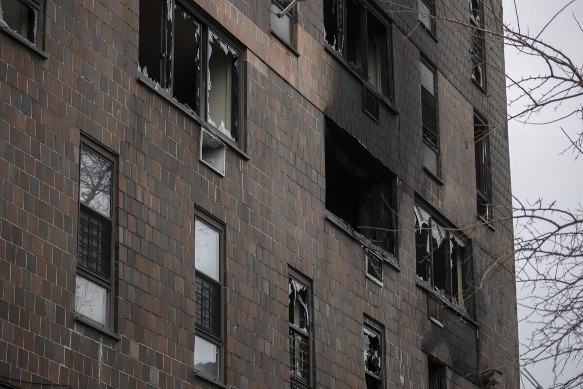 Broken windows are seen at the burned apartment building in the Bronx on Sunday in New York. 