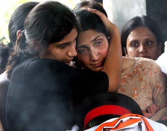 The widow of Indian Army Brigadier Ravi Datt Mehta, the military attache who was killed in a terror attack on the Indian embassy in Kabul, is held by a family member during a cremation ceremony in New Delhi. Mehta, a diplomat and three other Indian staff members at the heavily fortified embassy in Kabul were among the 41 people killed after a suicide bomber rammed an explosives-laden vehicle into the mission gates during the morning rush hour.