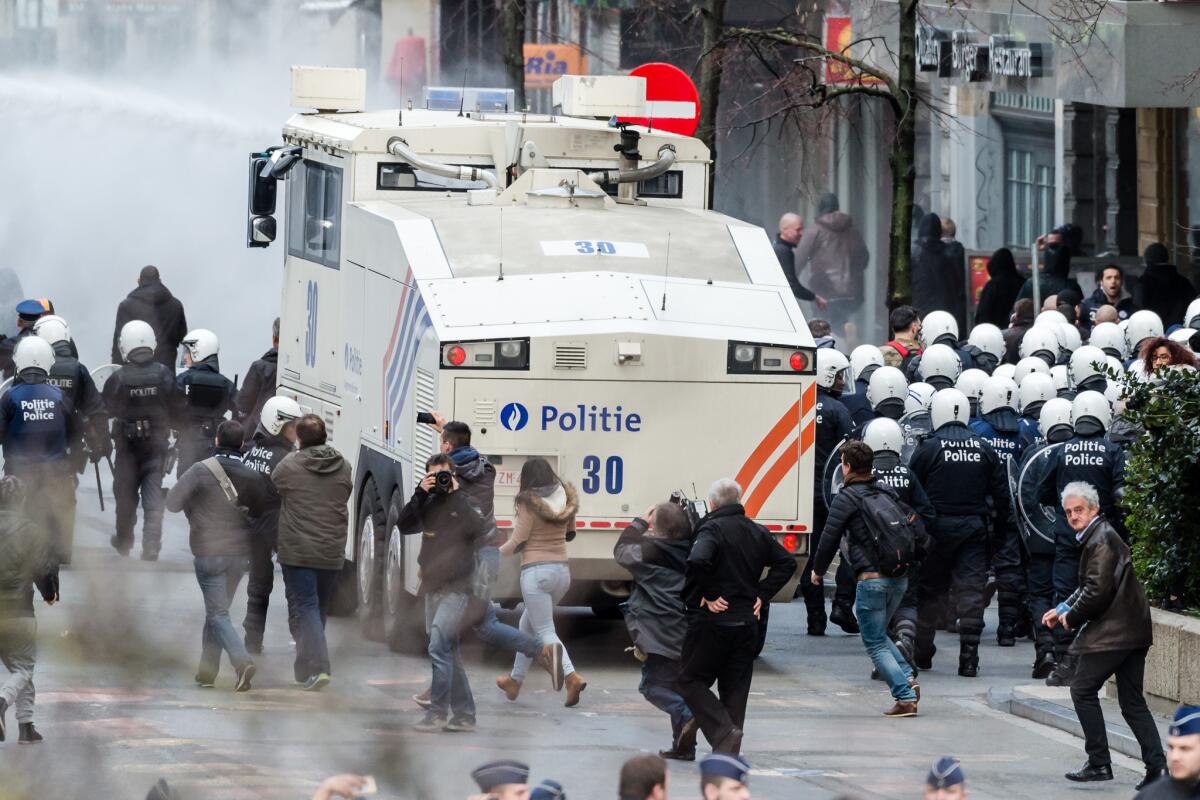 Police use a water cannon as demonstrators protest at a memorial site at the Place de la Bourse in Brussels on Sunday.