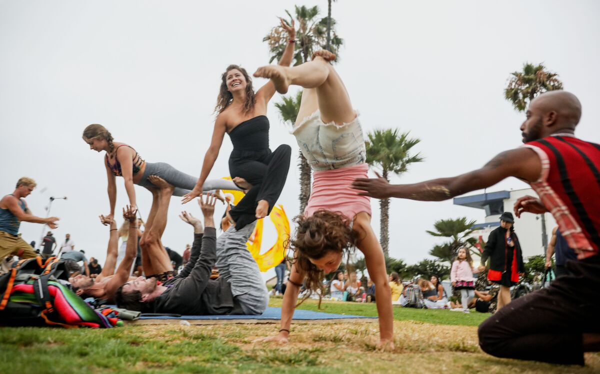 Exercisers do acrobatic mauevers in Ocean Beach on Wednesday, July 29, 2020.