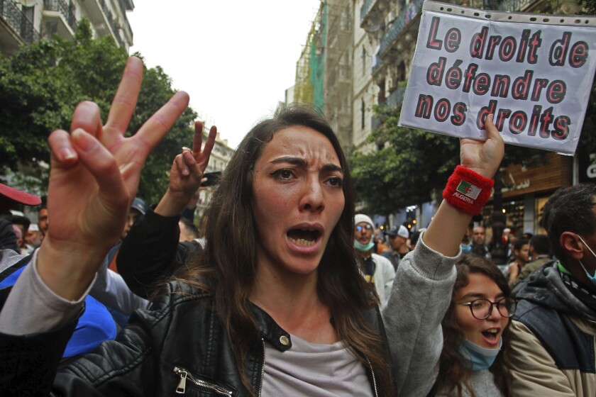 Algerian students demonstrate, one with a poster reading "The right to defend our rights" in Algiers, Tuesday, March 2, 2021. Protesters took to the streets of Algiers and other cities around Algeria last Friday in a bid to restart weekly pro-democracy demonstrations. (AP Photo/Fateh Guidoum)