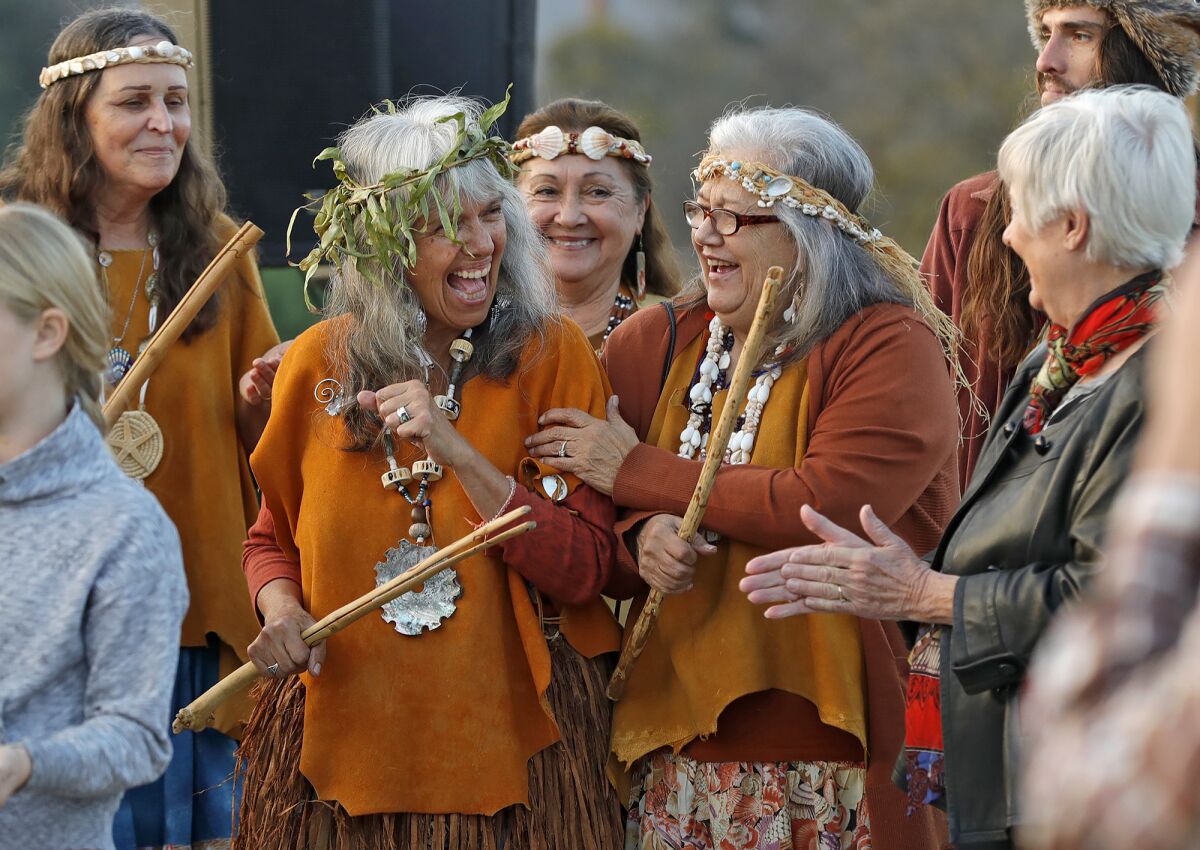 Juaneño spiritual leader Adelia Sandoval, second from left, laughs with guests at the Putuidem Village park.