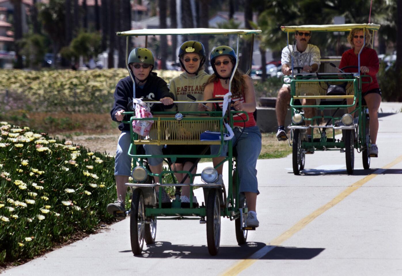 MA group in a surrey pedals along a bike path that runs along the beach.