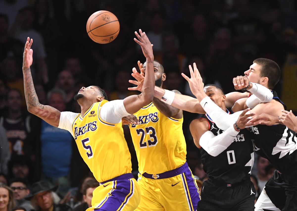 Les Lakers Cam Reddish saisit un rebond devant LeBron James et les Clippers Russell Westbrook