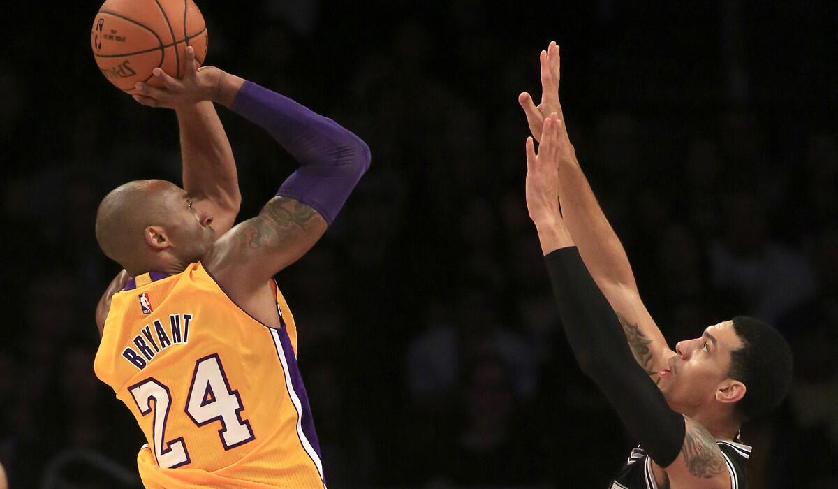 Lakers guard Kobe Bryant elevates for a shot over Spurs guard Danny Green in the first half.