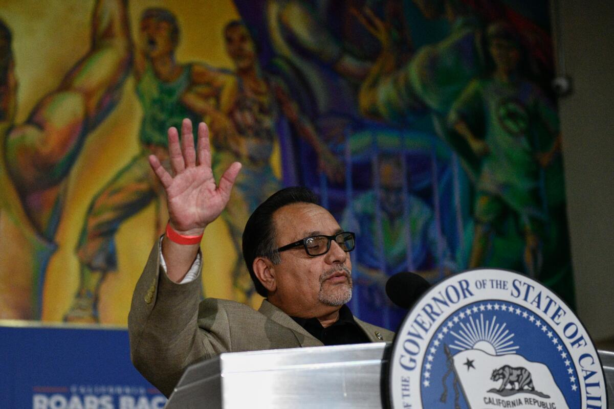 A man raises his right hand behind a lectern.