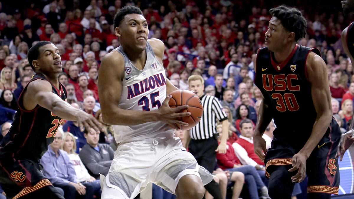 Arizona guard Allonzo Trier drives between USC's De'Anthony Melton, left, and Elijah Stewart (30) during the second half Thursday night.