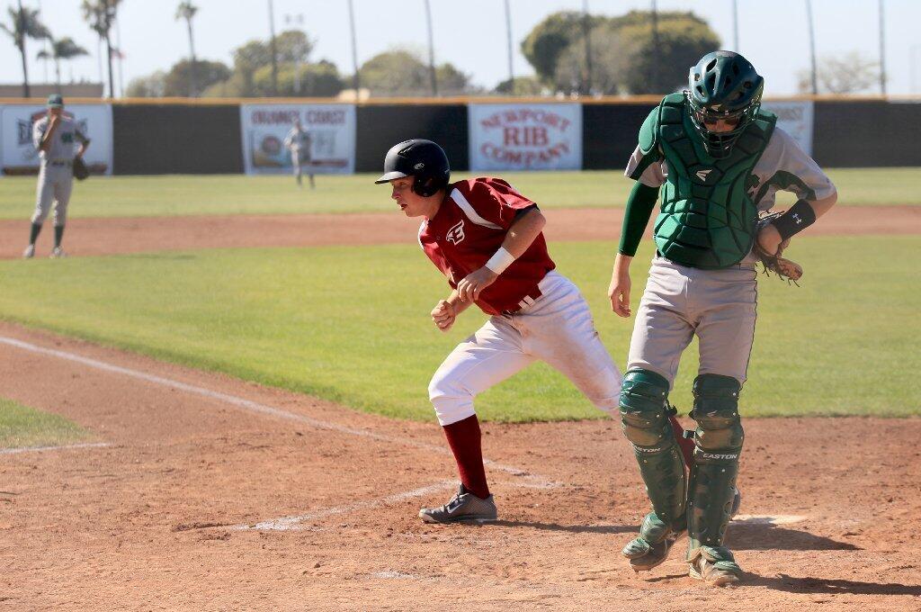 Costa Mesa High catcher James Barton, right, hangs his head as Estancia's Jackson Letterman, center, scores the first run of the game during the first inning on Wednesday in the second game of a three-game series.