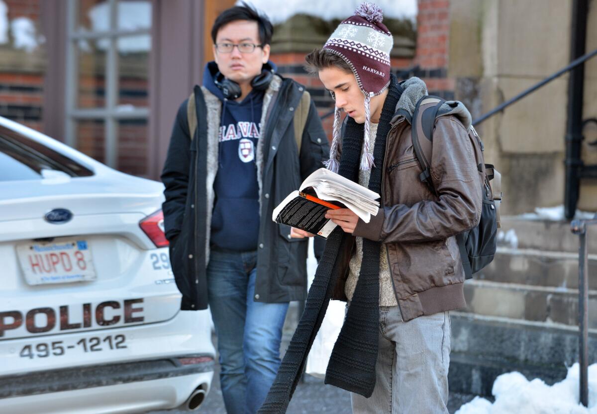 Students wait outside a building at Harvard University in Cambridge, Mass. Four buildings on campus were evacuated Monday after campus police received an unconfirmed report that explosives may have been placed inside, interrupting final exams.