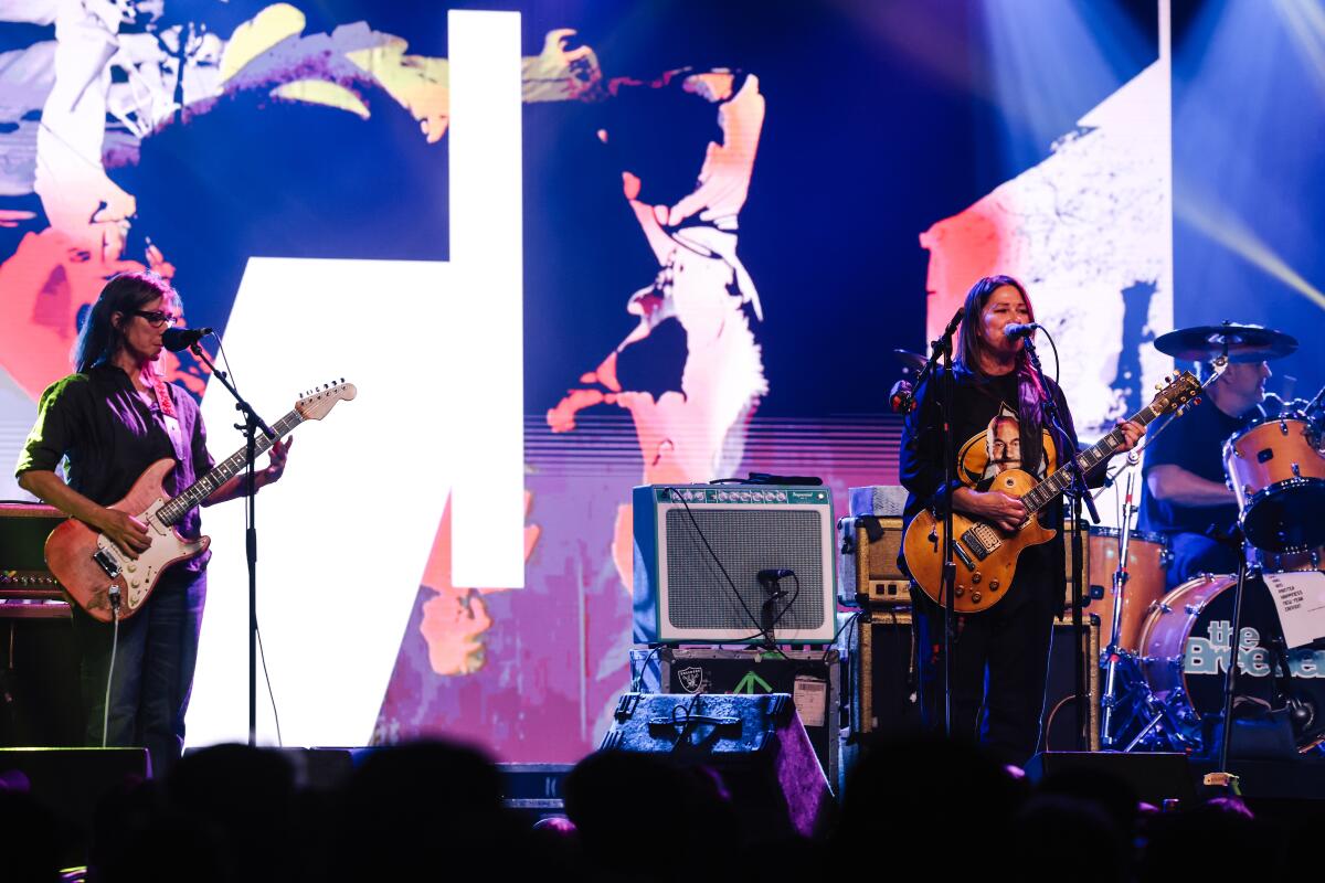 A rock band performs onstage