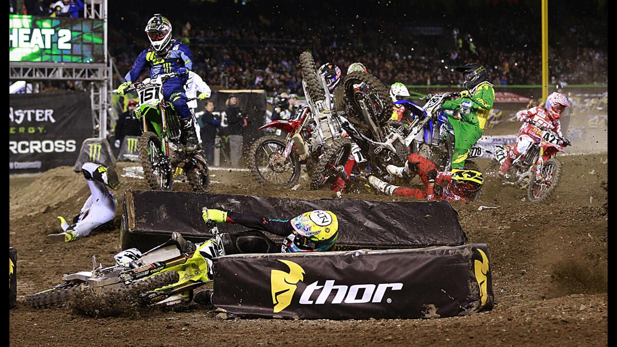 Riders in the 450SX heat 2 crash on the first turn during the Monster Energy AMA Supercross race at Angel Stadium on Jan. 9.