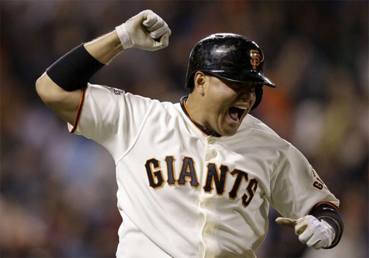 San Francisco Giants' Guillermo Quiroz celebrates as he rounds the bases after hitting a walkoff home run in the 10th inning against the Dodgers.