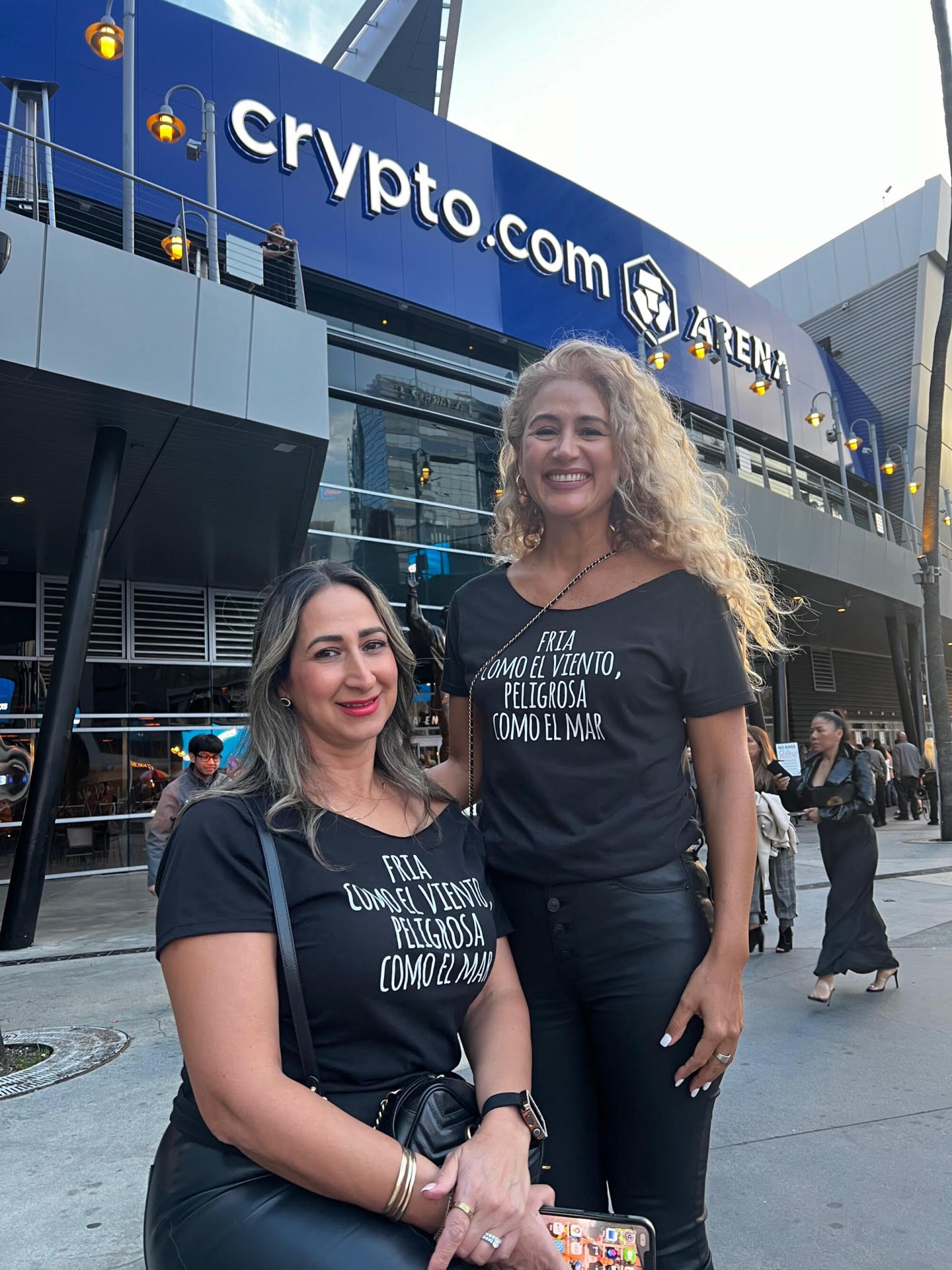 Cynthia y Alexis sonríen a la cámara con sus playeras impresas con la letra de uno de los éxitos 