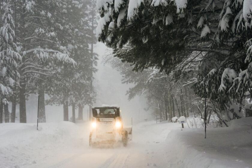 Se retira la nieve de una carretera durante una tormenta, 
