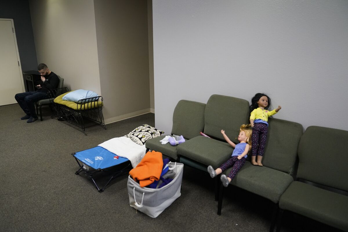 A man from Ukraine sits among donated toys at a shelter in the Christian church Calvary San Diego