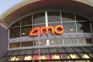 The exterior of an AMC Theatres with a glass front and a water fountain feature in the foreground