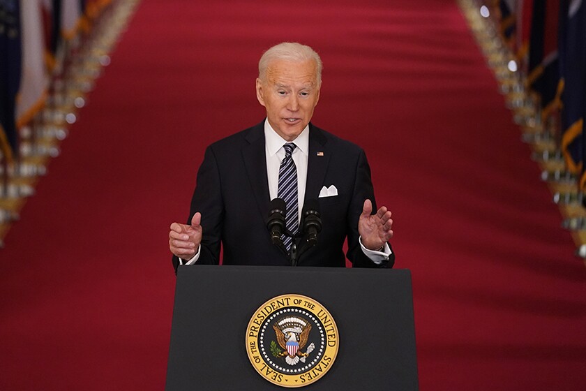 President Biden speaks at a lectern 
