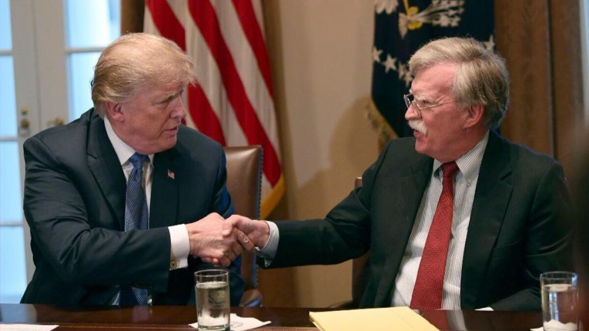 President Trump shakes hands with John Bolton on Bolton's first day as national security advisor, April 9, 2018. 