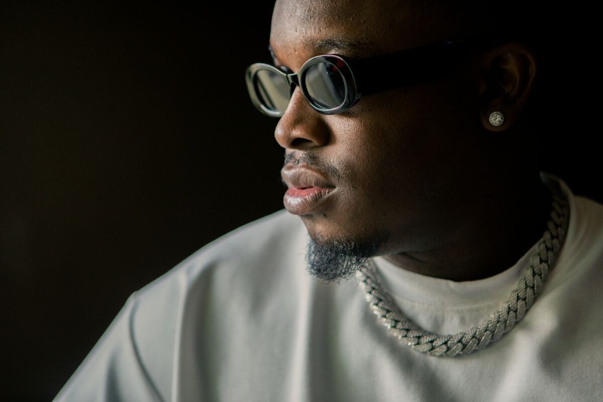 A rapper in sunglasses and a white shirt.